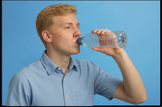 Il ragazzo beve l'acqua che aveva comprato al negozio